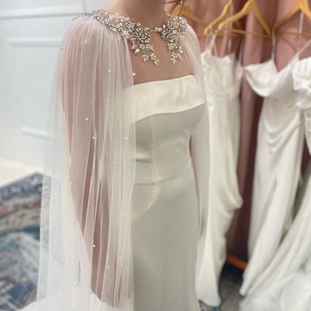 Elegant handmade Swiss veil cape, front closure with rhinestone & pearl details.